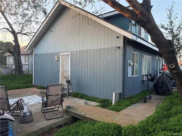 a backyard of a house with wooden fence and trees