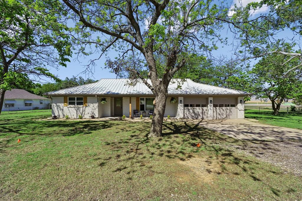913 North Main Street Springtown, TX 76082 - Photo 2 of 25 a front view of a house with a garden