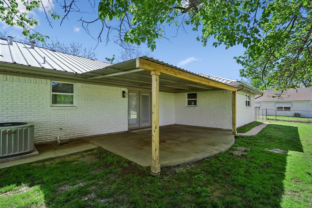 913 North Main Street Springtown, TX 76082 - Photo 21 of 25 a backyard of a house with table and chairs