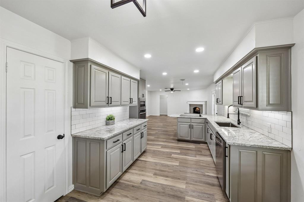 913 North Main Street Springtown, TX 76082 - Photo 4 of 25 a large kitchen with stainless steel appliances kitchen island granite countertop a sink and cabinets