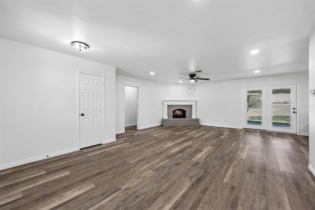 913 North Main Street Springtown, TX 76082 - Photo 6 of 25 an empty room with wooden floor chandelier and windows