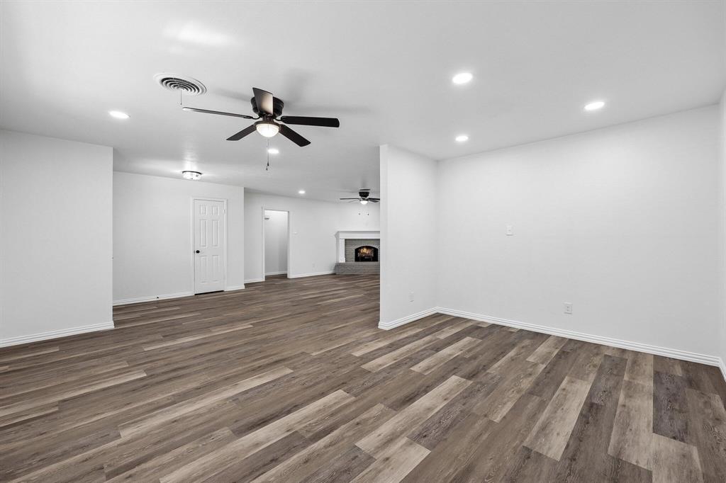 913 North Main Street Springtown, TX 76082 - Photo 8 of 25 an empty room with wooden floor ceiling fan and window