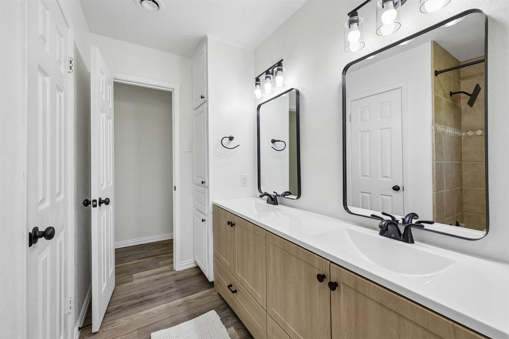 913 North Main Street Springtown, TX 76082 - Photo 10 of 25 a bathroom with a double vanity sink a mirror and a shower
