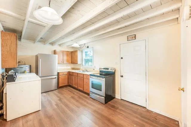 a kitchen with a refrigerator a sink and wooden floor
