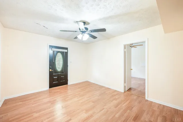 a view of a big room with wooden floor and a ceiling fan