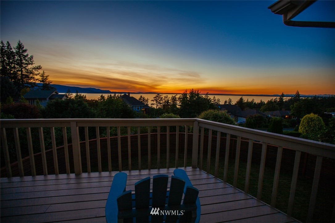 a balcony with wooden floor and sunset view