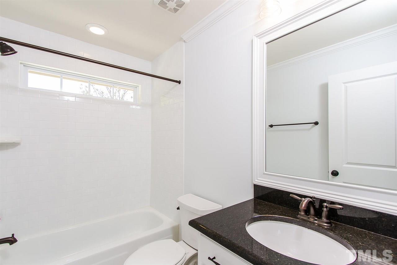 721 South State Street Raleigh, NC 27601 - Photo 15 of 25 a bathroom with a granite countertop sink toilet and a mirror