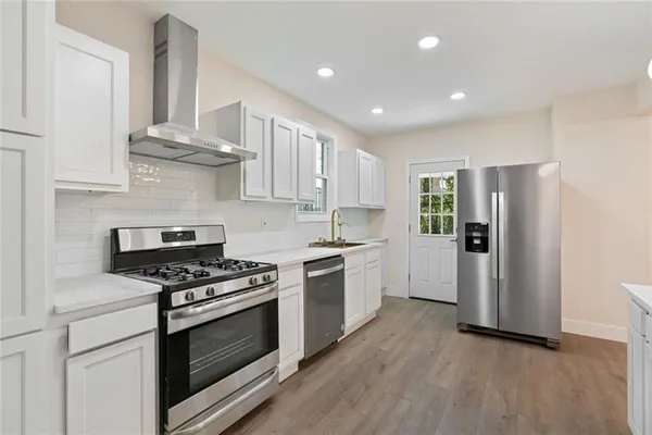a kitchen with stainless steel appliances a stove a sink and a refrigerator