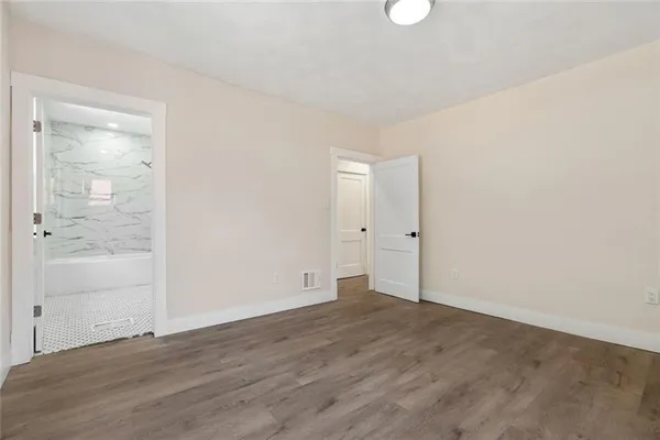 an empty room with wooden floor and mirror