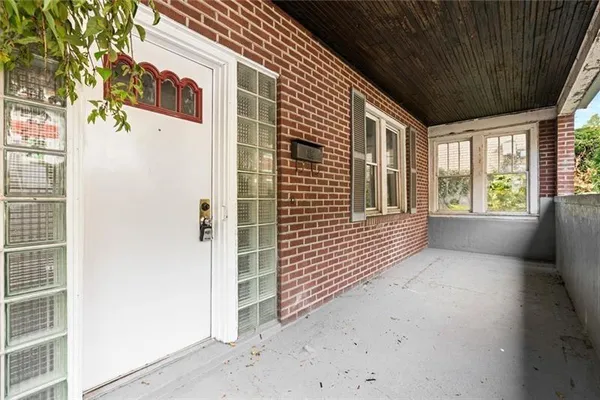 a view of a porch with wooden floor and a window