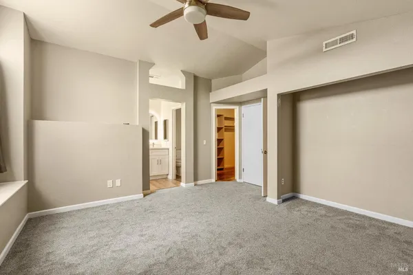 an empty room with closet and windows