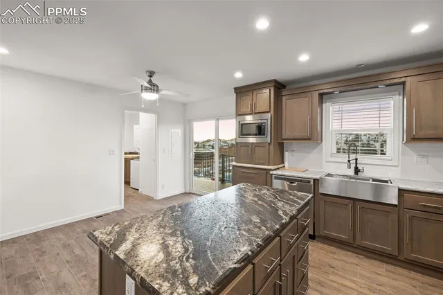 an empty room with kitchen appliances and wooden floor