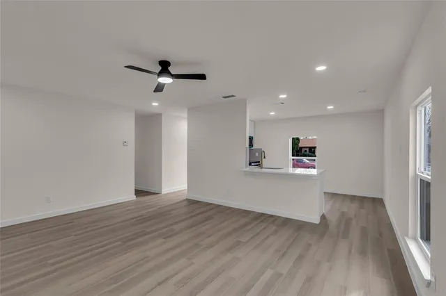 a view of a big room with wooden floor and a ceiling fan