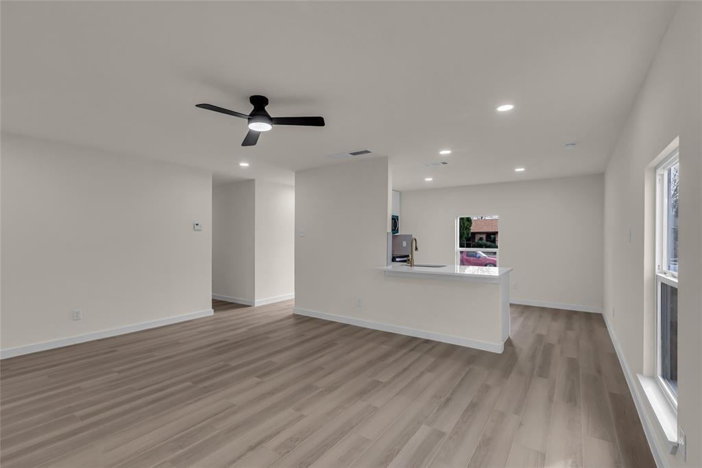 913 Roaming Rd Drive Allen, TX 75002 - Photo 5 of 21 a view of a big room with wooden floor and a ceiling fan