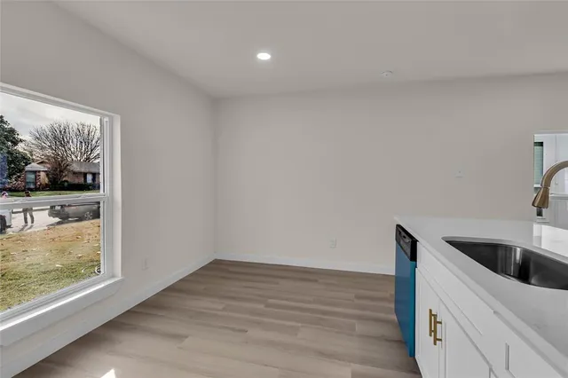 a kitchen with a wooden floor and a large window