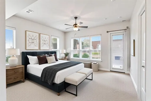 a spacious bedroom with a balcony a bed and a chandelier