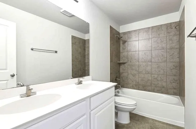 a bathroom with a bathtub shower sink vanity and toilet