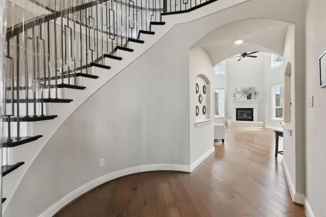 a view of a hallway with wooden floor and staircase
