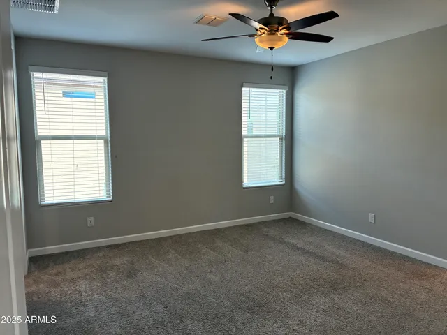 an empty room with windows and fan