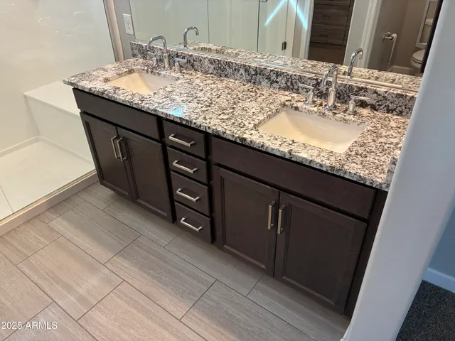 a bathroom with a granite countertop sink and shower