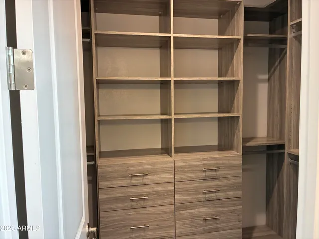 a view of walk in closet with empty racks