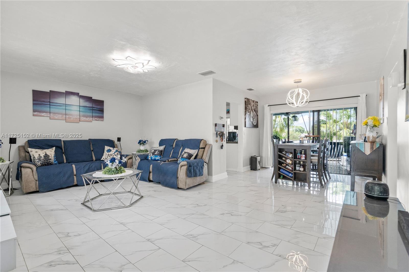 7271 Sunset Strip Sunrise, FL 33313 - Photo 22 of 45 a living room with furniture and a chandelier