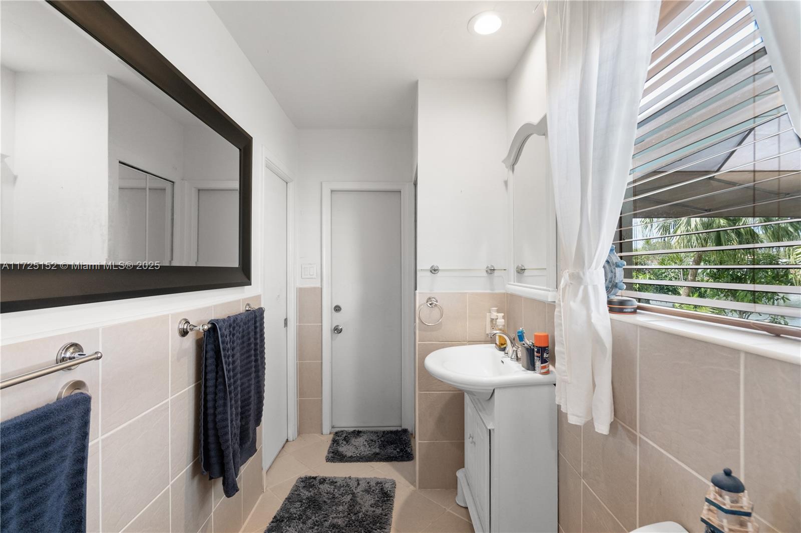 7271 Sunset Strip Sunrise, FL 33313 - Photo 29 of 45 a en suite bathroom with a sink and a mirror