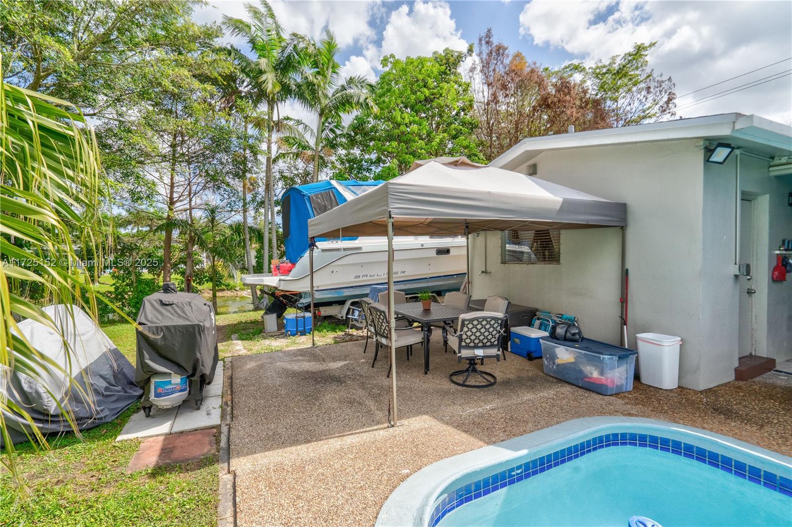 7271 Sunset Strip Sunrise, FL 33313 - Photo 41 of 45 a backyard of a house with table and chairs under an umbrella