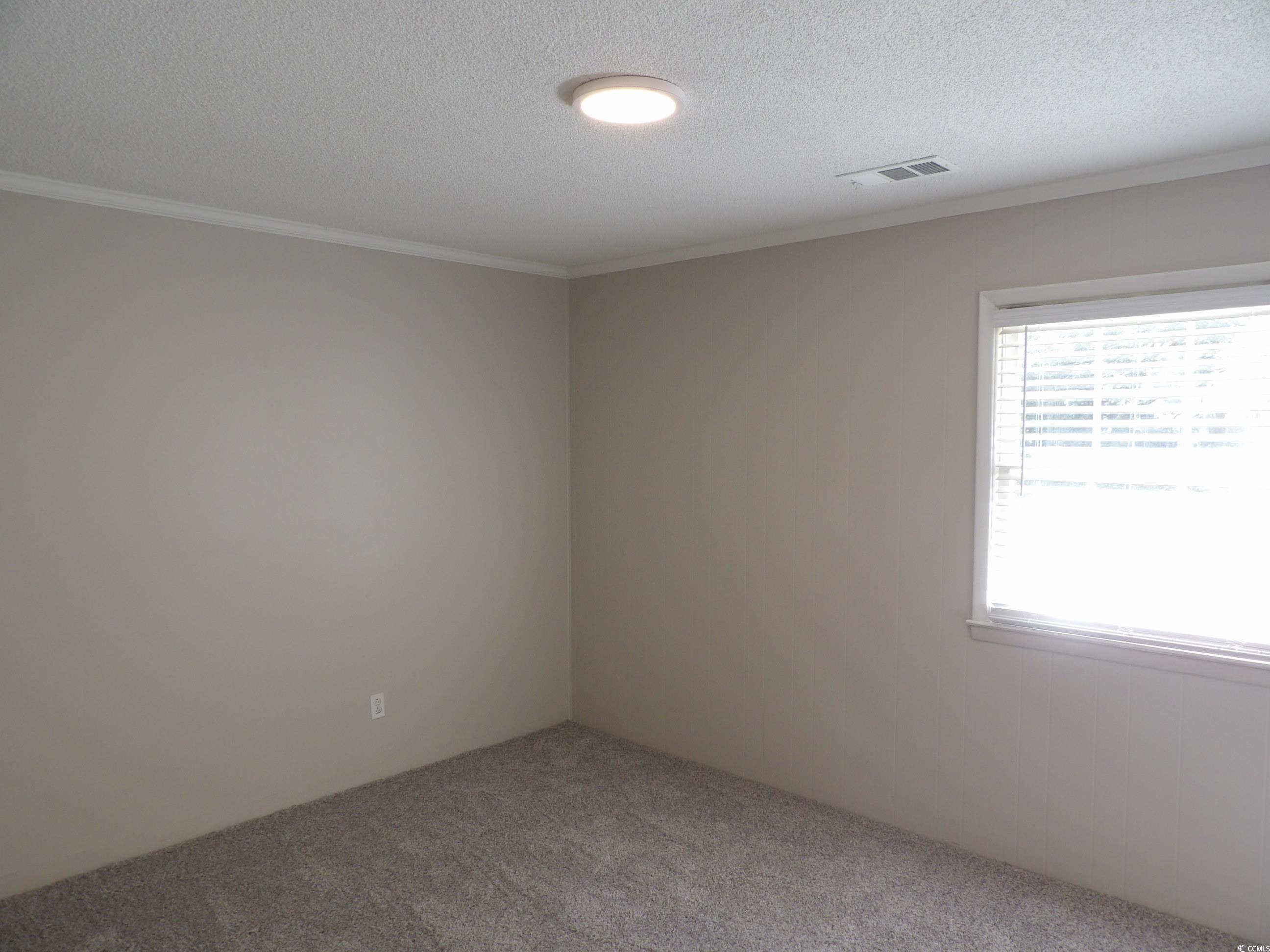 330 Stanley Drive Murrells Inlet, SC 29576 - Photo 4 of 32 Empty room featuring crown molding, a textured cei