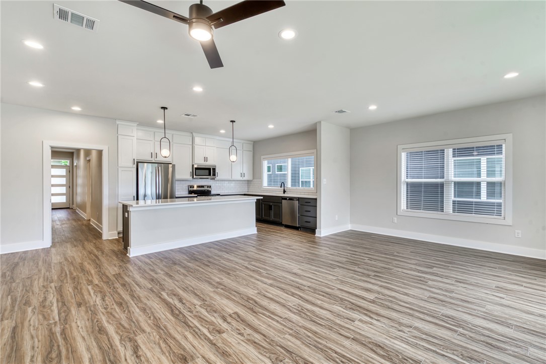 305 Cooner Street, Unit A College Station, TX 77840 - Photo 35 of 35 a large kitchen with stainless steel appliances granite countertop a large center island a stove a refrigerator with white cabinets and wooden floor