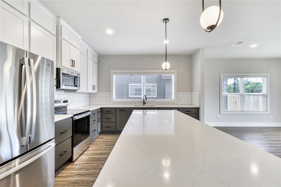 305 Cooner Street, Unit A College Station, TX 77840 - Photo 12 of 35 a large kitchen with kitchen island a large window and stainless steel appliances