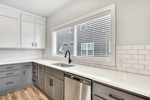 a kitchen with stainless steel appliances granite countertop a sink a refrigerator a center island a stove and a wooden floors