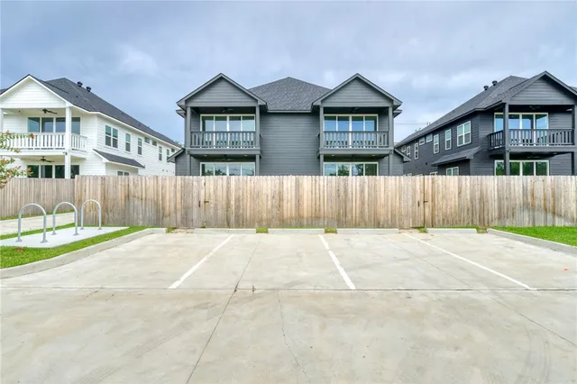 front view of a house with a yard and wooden fence