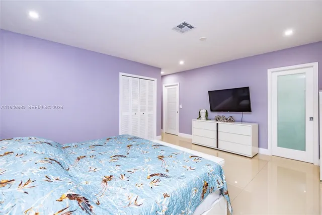 a bedroom with a bed and a flat screen tv