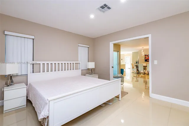 a bedroom with a large bed and a chandelier