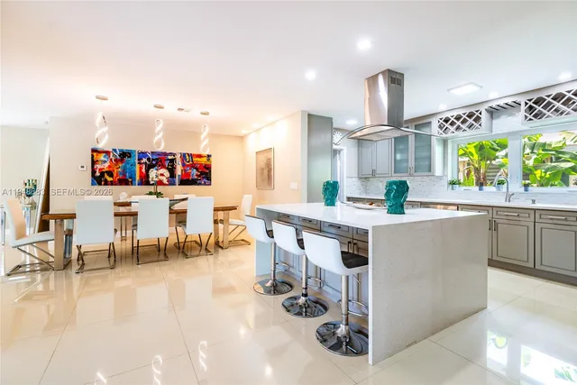 a kitchen with stainless steel appliances a table and chairs in it