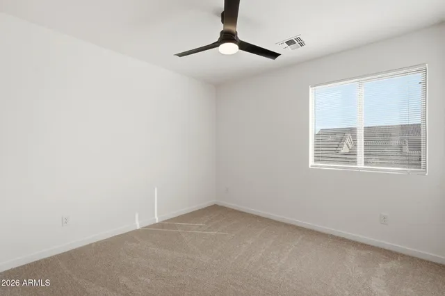 an empty room with windows and fan