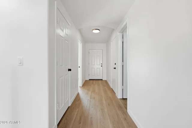 a view of a hallway with wooden floor and closet