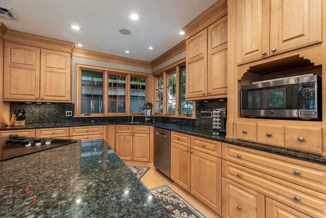 a kitchen with stainless steel appliances granite countertop a refrigerator and a stove top oven