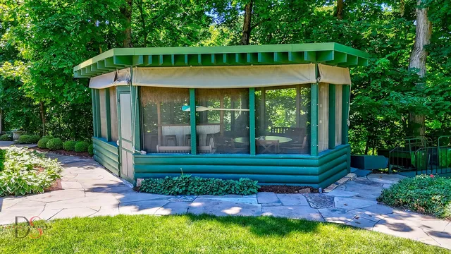 a view of a patio with a table and chairs under an umbrella with a tub