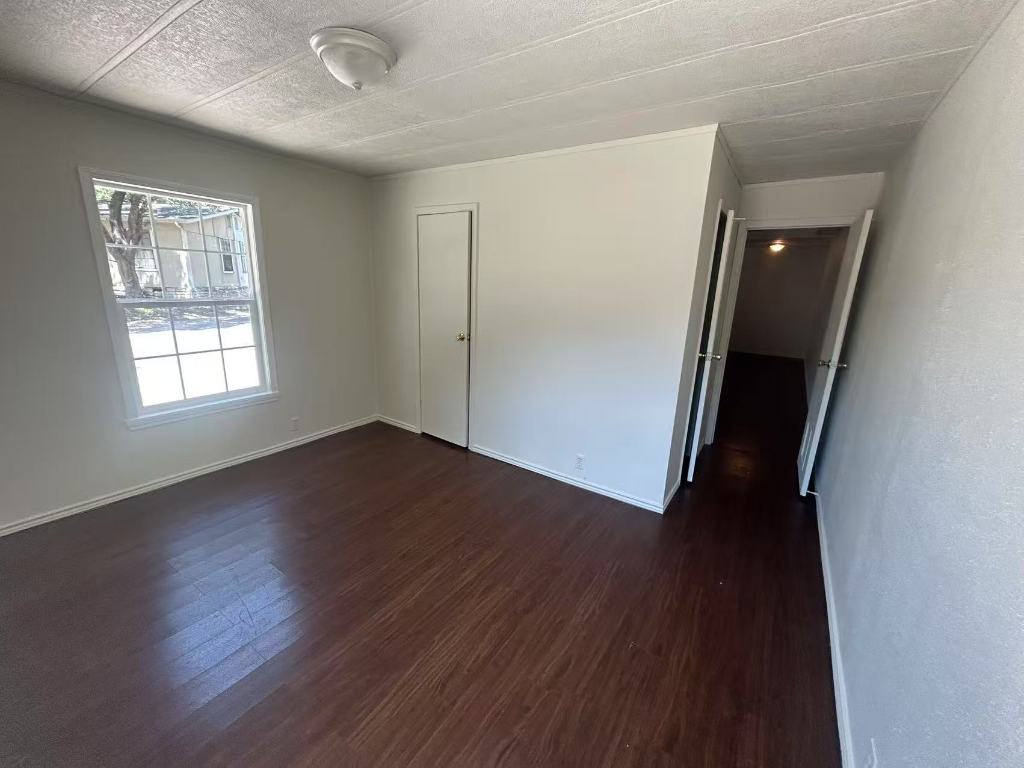 23393 Nameless Road, Unit 123 Leander, TX 78641 - Photo 5 of 15 an empty room with wooden floor and windows