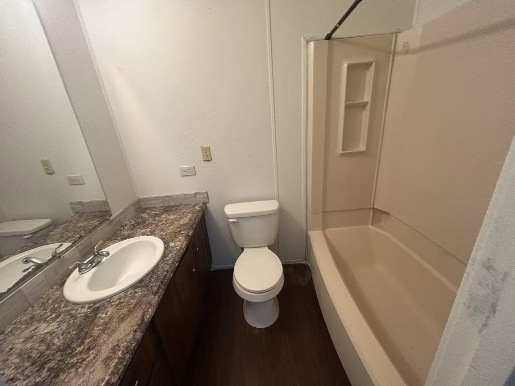 23393 Nameless Road, Unit 123 Leander, TX 78641 - Photo 6 of 15 a bathroom with a granite countertop sink toilet and shower