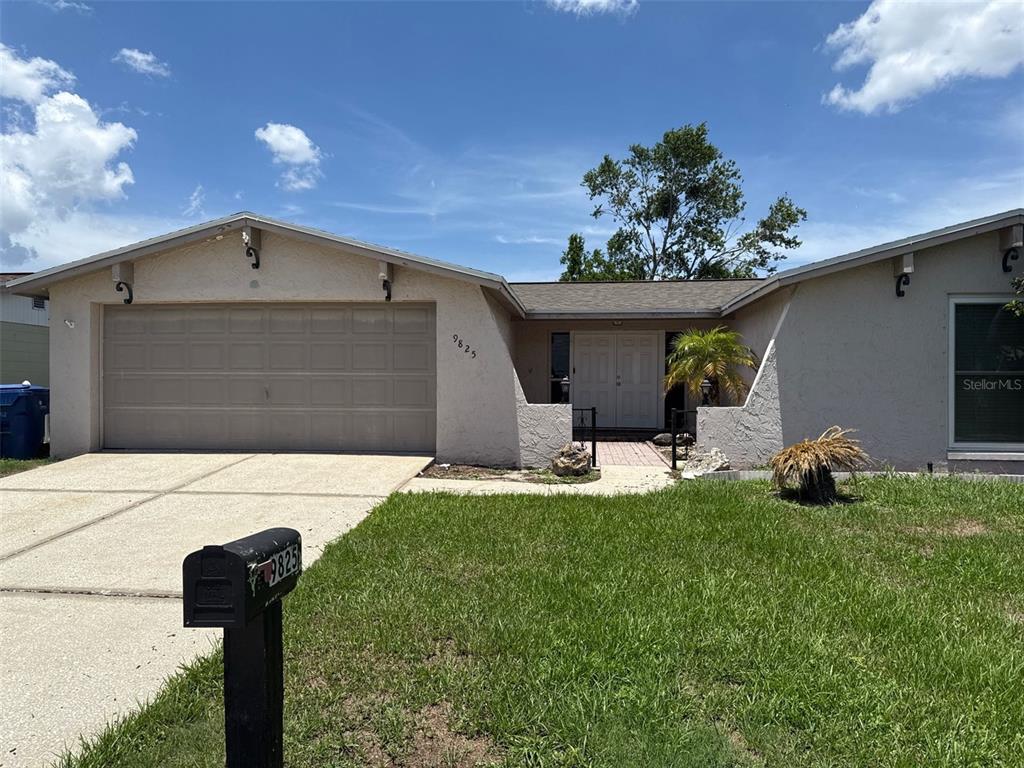 9825 Sandstone Lane Port Richey, FL 34668 - Photo 1 of 1 a front view of a house with garden