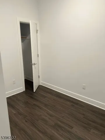 an empty room with wooden floor and closet