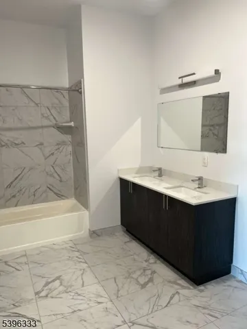 a bathroom with a sink vanity and bathtub