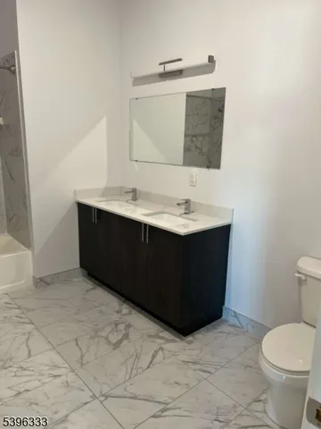 a bathroom with a sink vanity and toilet