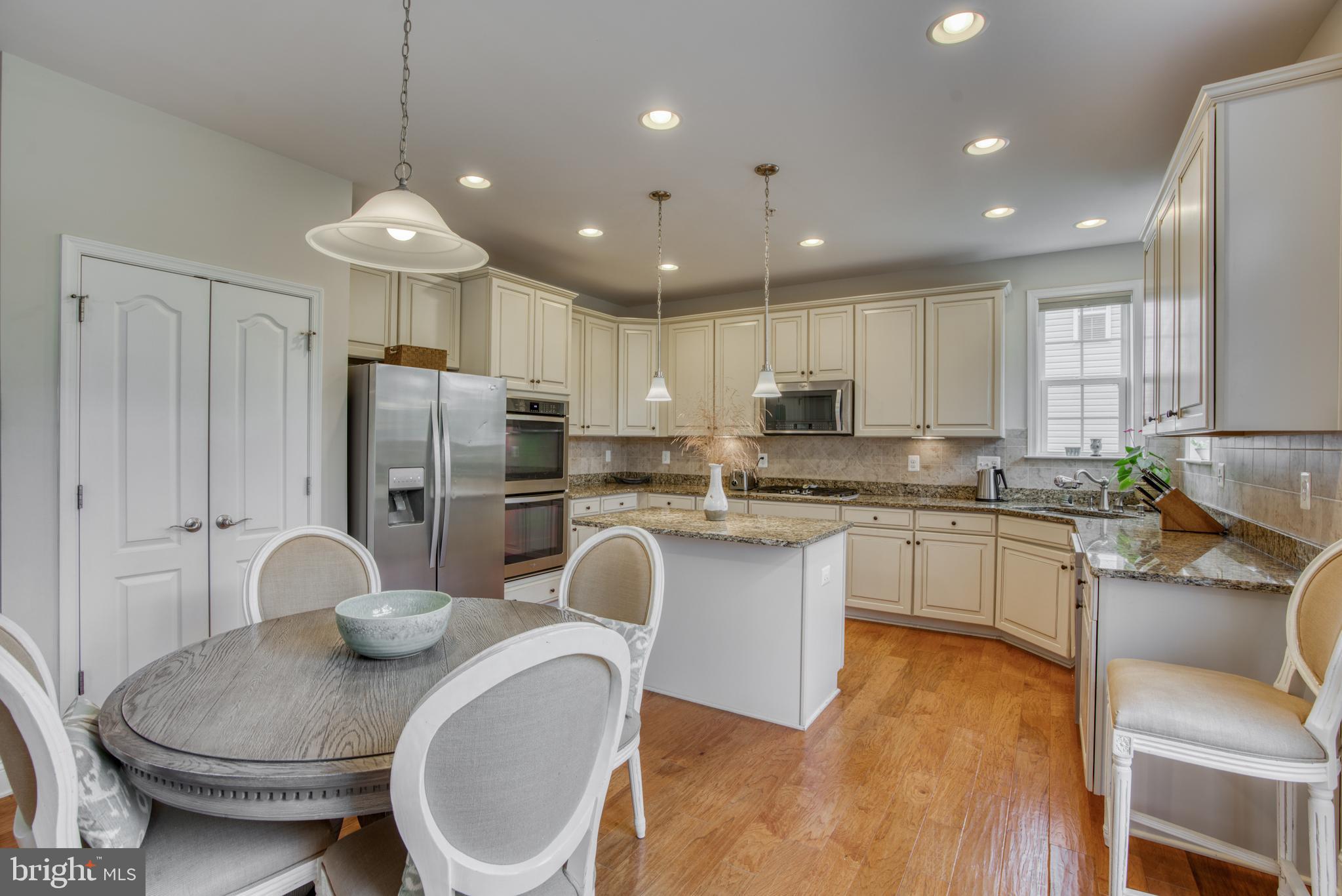 2344 Sweet Meadow Road Baltimore, MD 21209 - Photo 26 of 76 a kitchen with stainless steel appliances granite countertop a kitchen island a stove a table and chairs