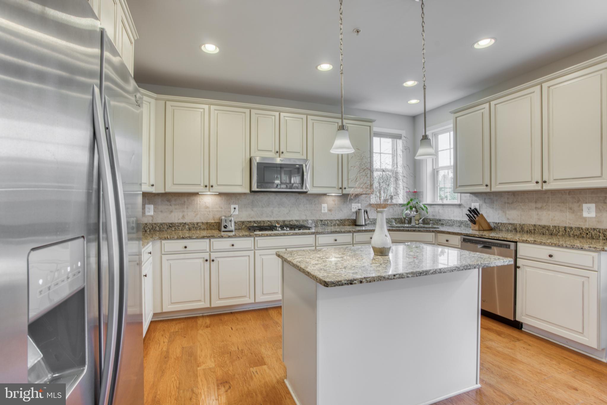 2344 Sweet Meadow Road Baltimore, MD 21209 - Photo 27 of 76 a kitchen with kitchen island granite countertop a sink stainless steel appliances and white cabinets