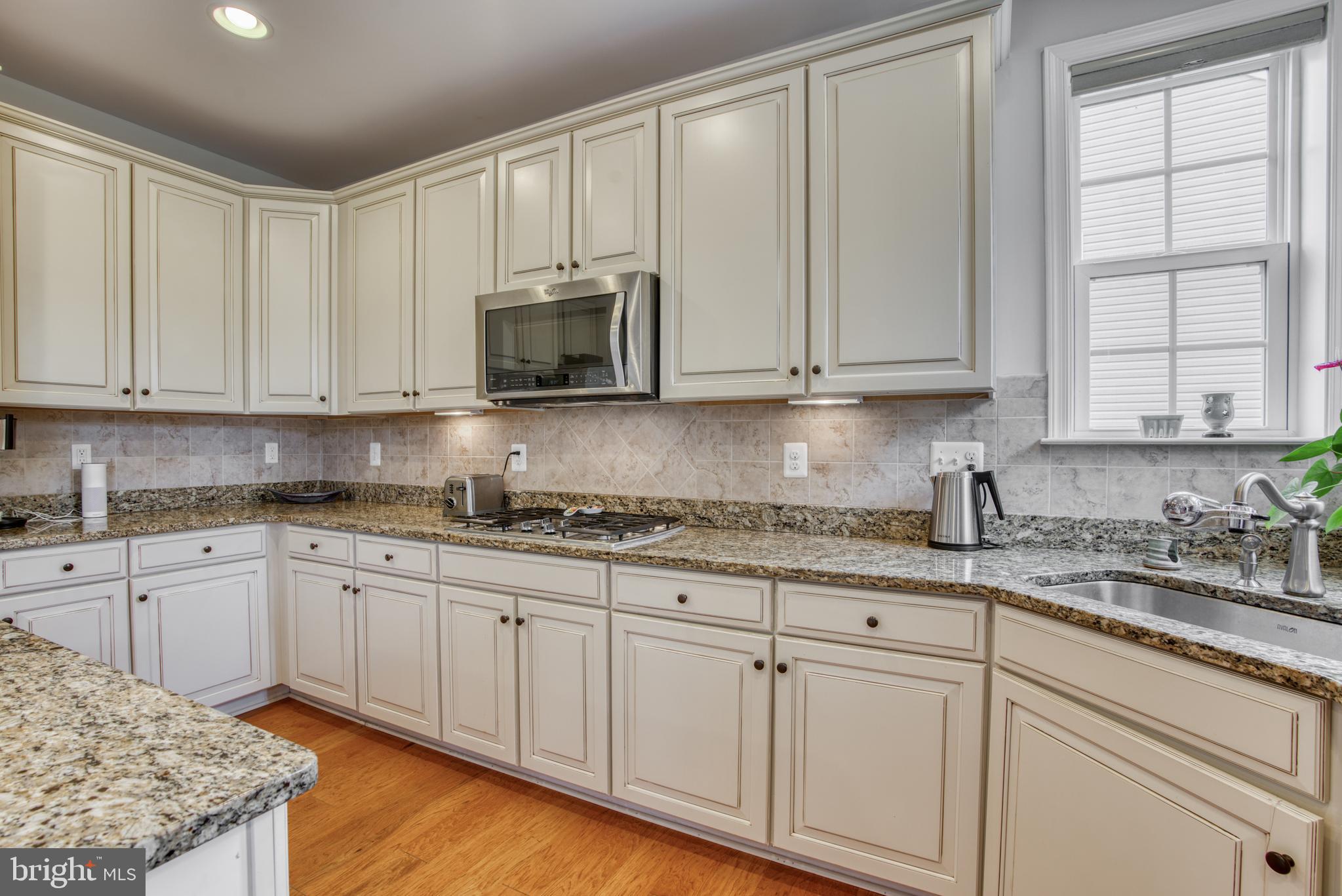 2344 Sweet Meadow Road Baltimore, MD 21209 - Photo 31 of 76 a kitchen with granite countertop white cabinets and sink