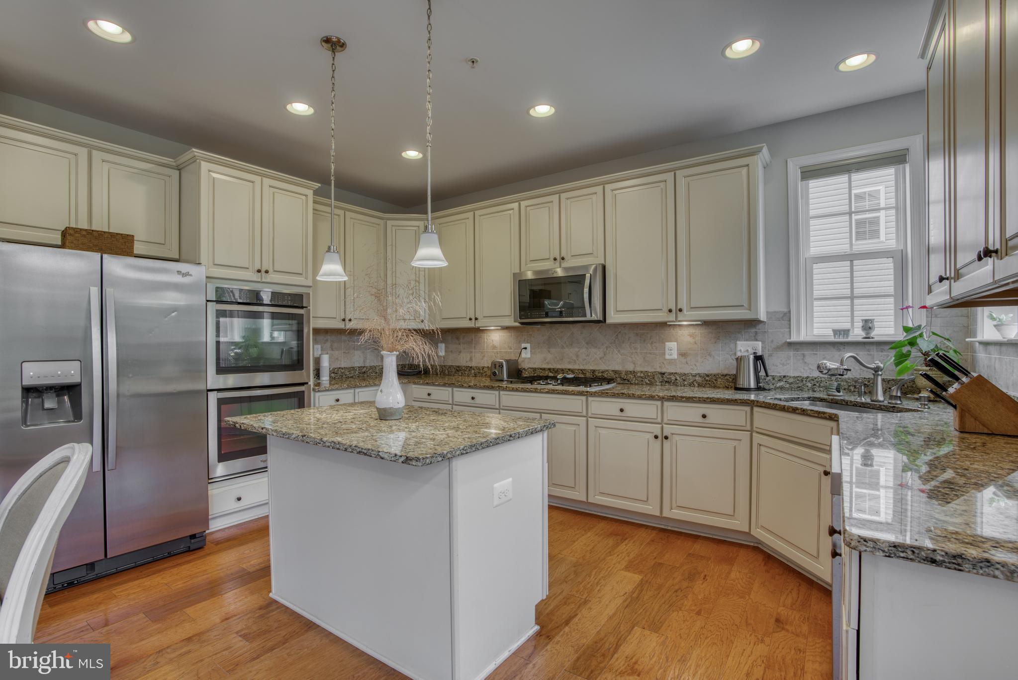 2344 Sweet Meadow Road Baltimore, MD 21209 - Photo 7 of 76 a kitchen with stainless steel appliances granite countertop a refrigerator a sink dishwasher a stove and white cabinets with wooden floor